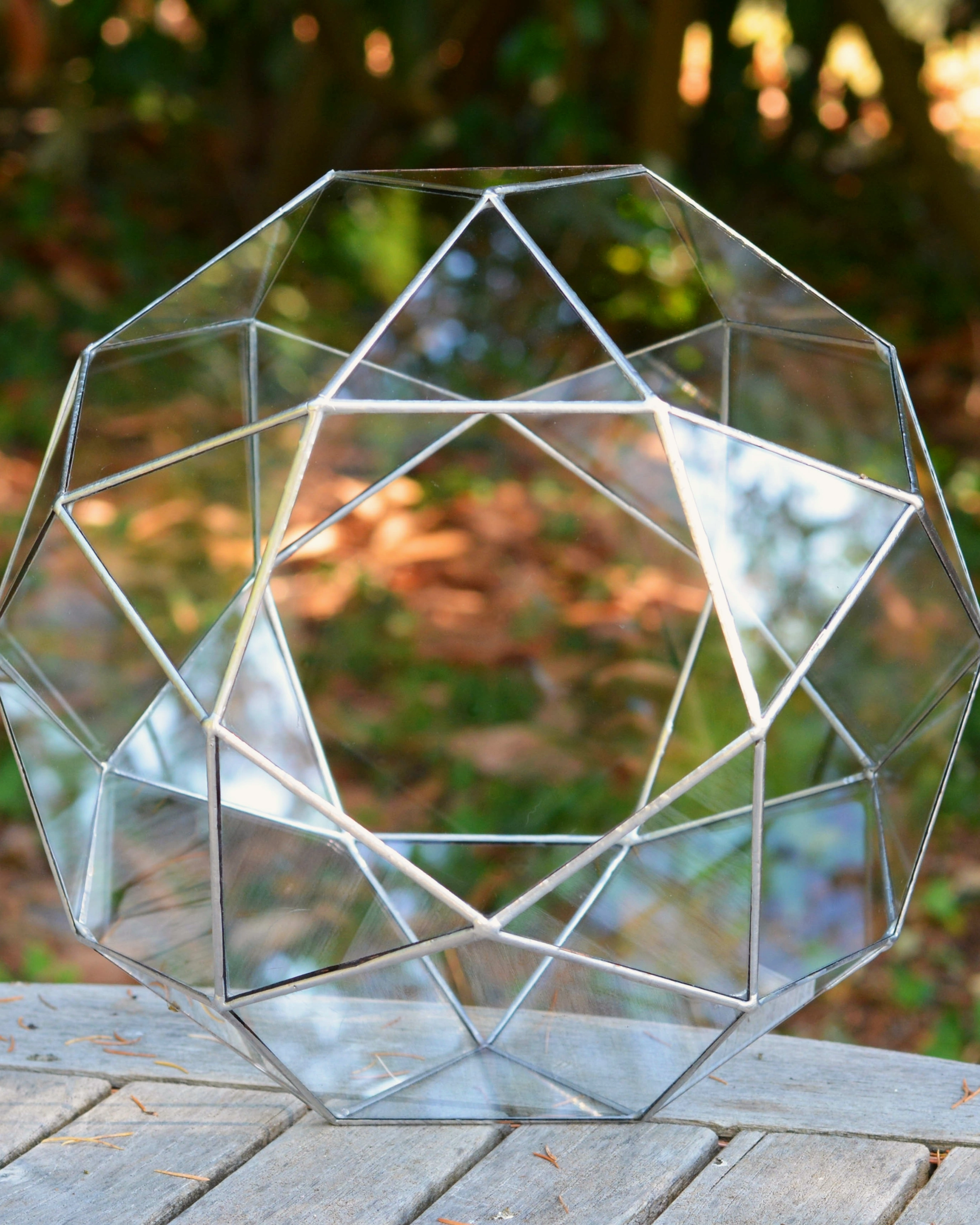 Silver icosidodecahedron resting on the garden table