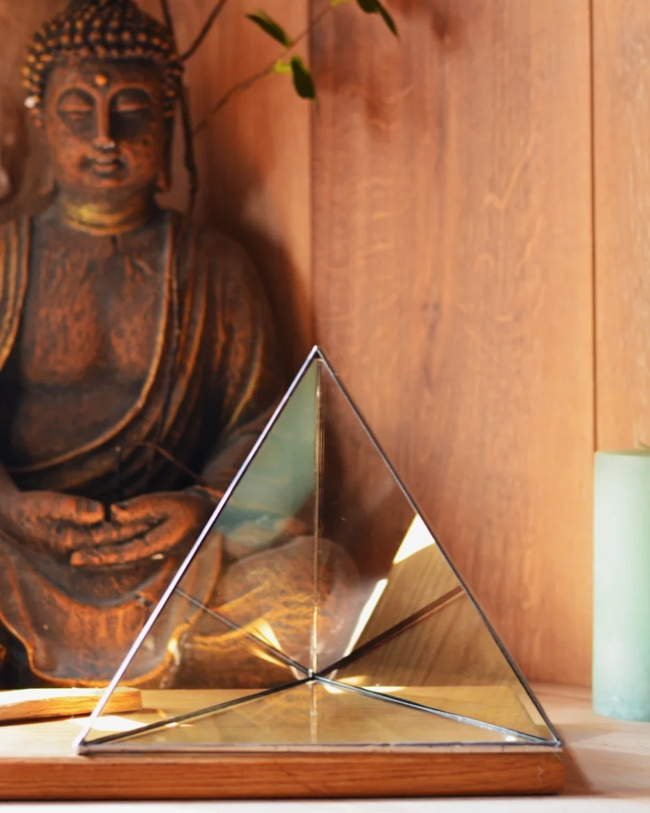 Glass tetrahedron, close-up in front of the Buddha