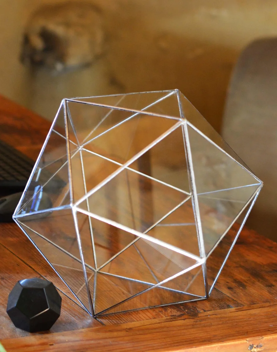 Icosahedron resting on a wooden desk