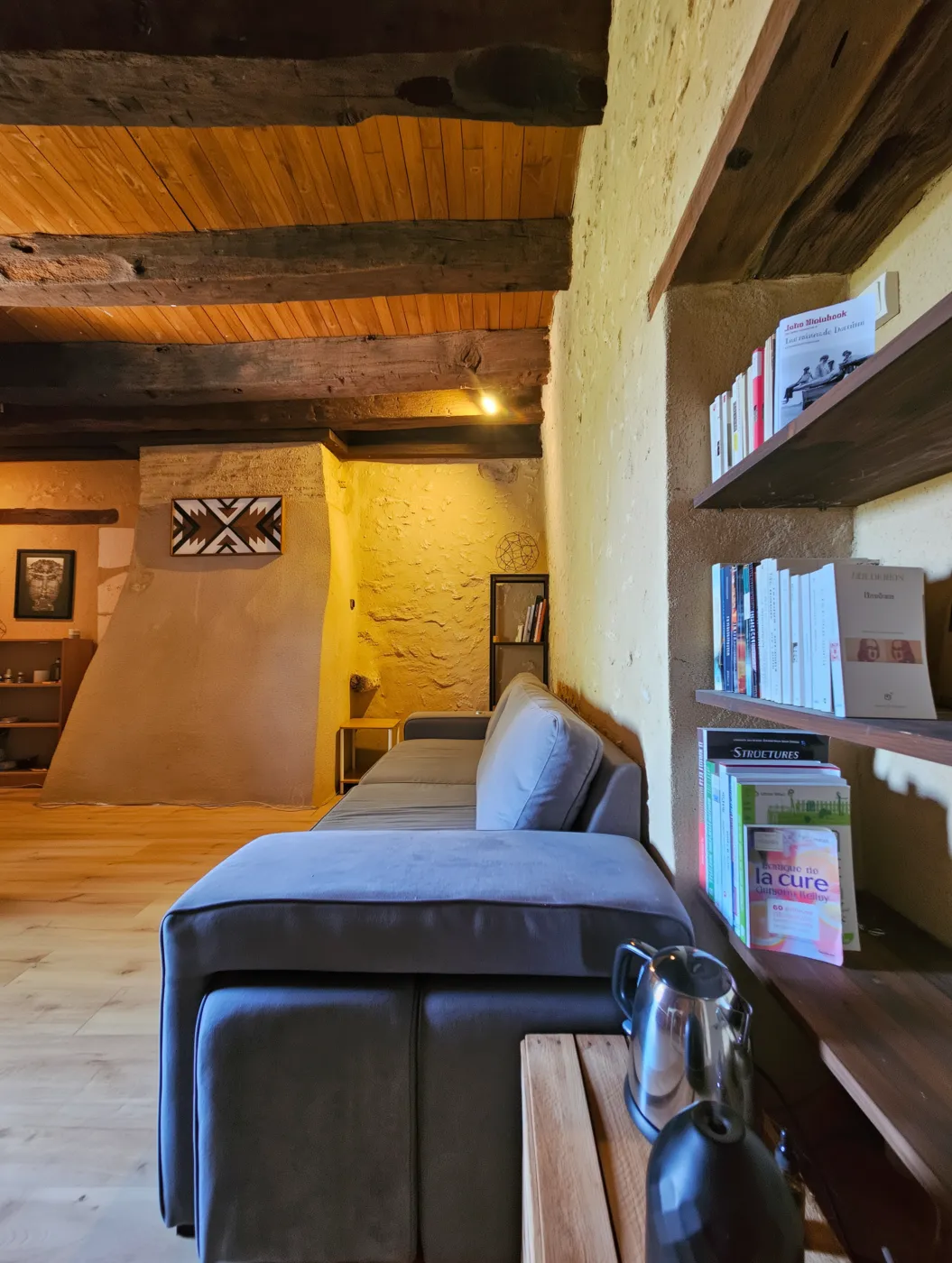 The room's sitting corner: sofa and bookcase, exposed stone