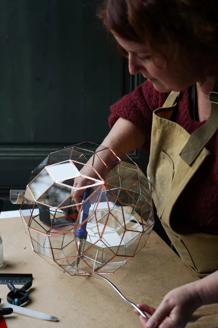 Priscille soudant un zome dans son atelier (© Cléa Mosaïque)